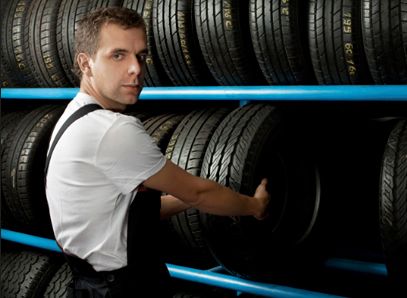 Enrique Castiñeiras Taller mecánico sosteniendo un neumático 